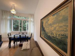 a living room with a couch and a painting on the wall at FLAT FAMÍLIA in Petrópolis