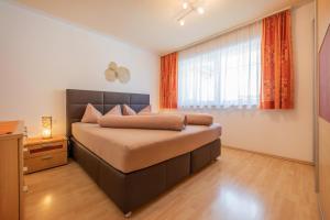 Un dormitorio con una cama grande y una ventana en Apartments Nadine, en Neustift im Stubaital