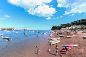 a group of people on a beach with boats at North View cottage. Shaldon village. in Shaldon