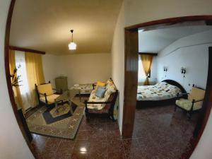 Habitación con cama y sala de estar con espejo. en Hotel Garant en Sandanski