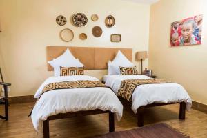 En eller flere senge i et værelse på Acacia Tree Lodge