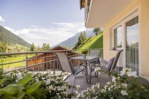 balcón con mesa, sillas y montañas en Apartments Nadine, en Neustift im Stubaital