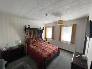 sypialnia z łóżkiem z czerwoną narzutą w obiekcie The Griffin Llyswen w mieście Brecon