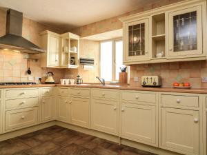 una cocina con armarios blancos y fregadero en Park House, en Torquay