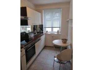 a kitchen with white cabinets and a table and a window at Apartment Stadthaus Perleberg in Perleberg