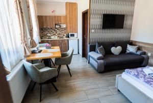 a small living room with a table and a couch at Allium Apartment in Mak&oacute;