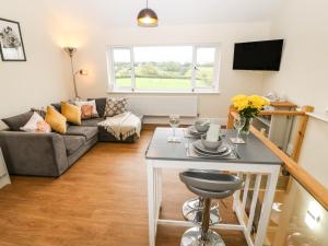 a living room with a table and a couch at Ty Gwair The Hayloft in Caernarfon