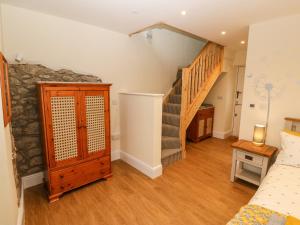a room with a staircase and a stone wall at Ty Gwair The Hayloft in Caernarfon