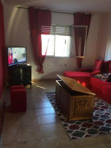 a living room with a red couch and a tv at Casa Campanita in Ribadeo