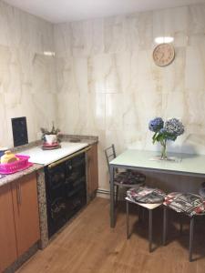 a kitchen with a table and two chairs and a table at Casa Campanita in Ribadeo