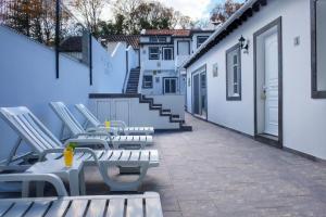 una fila de sillas y mesas blancas en un patio en Vale dos Encantos, en Furnas