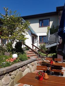 a patio with wooden tables and chairs and a building at Nielsen Appartment 2 in Hüsby