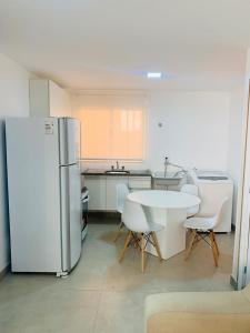 eine Küche mit einem Kühlschrank sowie einem Tisch und Stühlen in der Unterkunft Apartamento no Tremembé/Tucuruvi apto 06 in São Paulo
