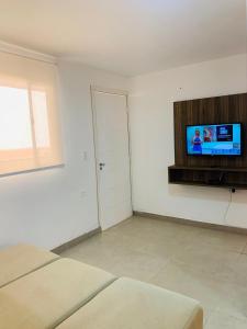 ein Wohnzimmer mit einem Flachbild-TV an der Wand in der Unterkunft Apartamento no Tremembé/Tucuruvi apto 06 in São Paulo