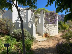 a white house with a white fence and flowers at Kleinkloof Farm in Piketberg