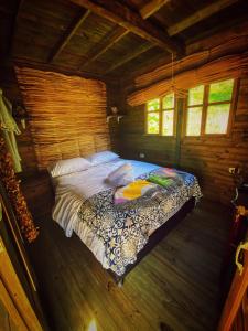 a bedroom in a wooden cabin with a bed at Cabaña Agrreste in Nemocón