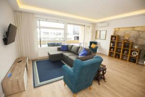 ポルトにあるGolden & Blue House, o seu novo espaço no Portoのソファと青い椅子のあるリビングルーム