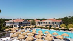 un resort con piscina e ombrelloni di Summer Time Family Resort a Bibione
