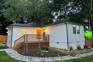 a small house with a large deck in a yard at ATL XPLOR (8mins to Airport/10mins to midtown) in Atlanta