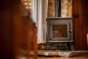 estufa de leña en una habitación con ventana en CASA VELHA, en Cernache do Bonjardim