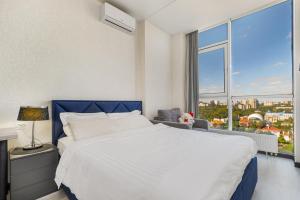 New apartments in Arcadia sea view في أوديسا: غرفة نوم بسرير كبير ونافذة كبيرة