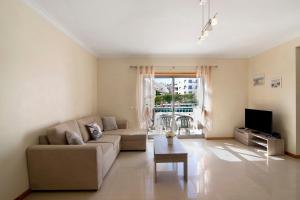 a living room with a couch and a tv at Apartamento Água Brisa in Albufeira