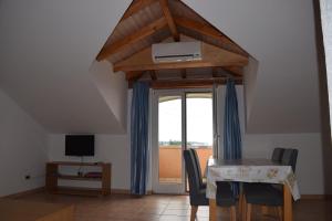 a dining room with a table with chairs and a window at Apartments Grgic in Novigrad Istria