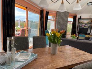 een vaas met bloemen op een houten tafel bij Zeester 6 personen * in Julianadorp