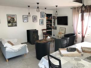 a living room with a couch and chairs and a television at Aux Jardins De La Guyonnière Gîte 2 à 13 personnes in Ruaudin
