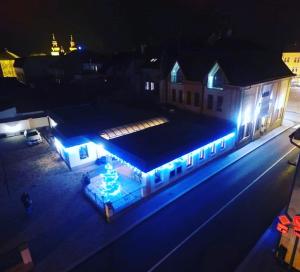 a building with blue lights on a street at night at Hotel Krajka**** in Wamberg