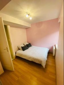 a bedroom with a bed with two pillows on it at Bel appartement cœur de ville in Chalon-sur-Saône