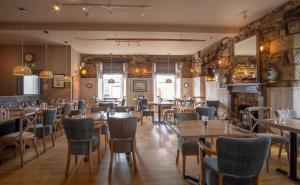 a restaurant with tables and chairs in a room at Marazion Hotel in Marazion