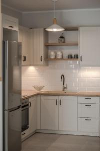 a kitchen with white cabinets and a stainless steel refrigerator at Cabanelli in Zakynthos Town