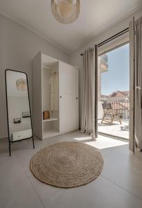 a white room with a mirror and a rug at Cabanelli in Zakynthos Town