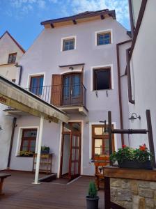 ein großes weißes Haus mit einer Veranda und einem Balkon in der Unterkunft Hotel Svambersky dum in Český Krumlov