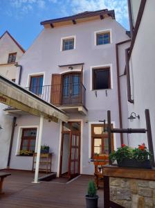una grande casa bianca con portico e balcone di Hotel Svambersky dum a Cesky Krumlov