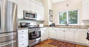 uma cozinha com armários brancos e um frigorífico de aço inoxidável em 5025 Main Gore Place Condo em Vail