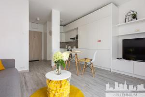 ein Wohnzimmer mit einem Sofa und einem Tisch in der Unterkunft Millennium Manufaktura Yellow in Warschau