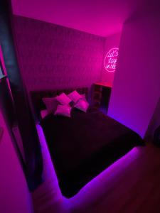 um quarto roxo com uma cama com almofadas em Secret Apartments Chełmska 55m2 em Varsóvia