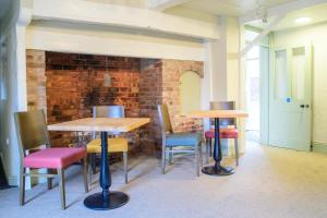 a room with two tables and chairs and a brick wall at The Old Kings Head in Boston