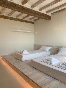 La Pervinca - Ospitalità, Natura, Cura في غواستالا: سريرين في غرفة بجدران بيضاء وأرضية خشبية