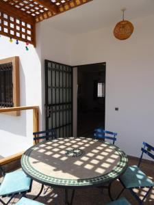 a patio with a table and chairs in a room at Dar Nezha in Imsouane