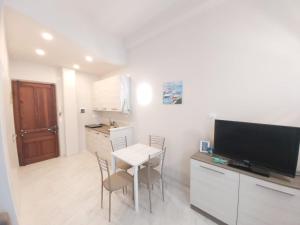 a small kitchen with a table and a television in a room at Casa Mazzini in Alassio