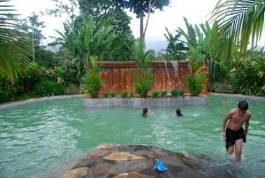 un grupo de personas nadando en una piscina en Blue River Resort & Hot Springs, en Liberia