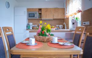 a kitchen with a table with plates and flowers on it at Apartment Haus Maria Waldblick in Burtenbach