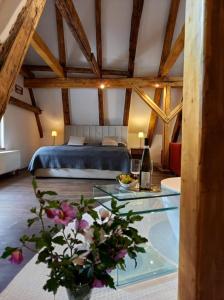 1 dormitorio con 1 cama y 1 mesa con flores en Hotel Svambersky dum en Český Krumlov