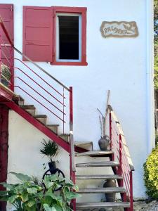 een huis met een rode deur en een trap bij "Palomar", duplex de charme 80m2 - 2 ch - 2 sdb - parking et terrasse in Saint-Jean-de-Luz