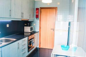 uma cozinha com um frigorífico branco e um lavatório em REFÚGIO LOURO • gym - pool - tennis em Leça da Palmeira
