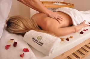 a woman laying on a bed getting a massage at Ruca Kuyen Golf & Resort in Villa La Angostura