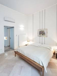 a white bedroom with a large bed in it at Palazzo Charlie in Lecce